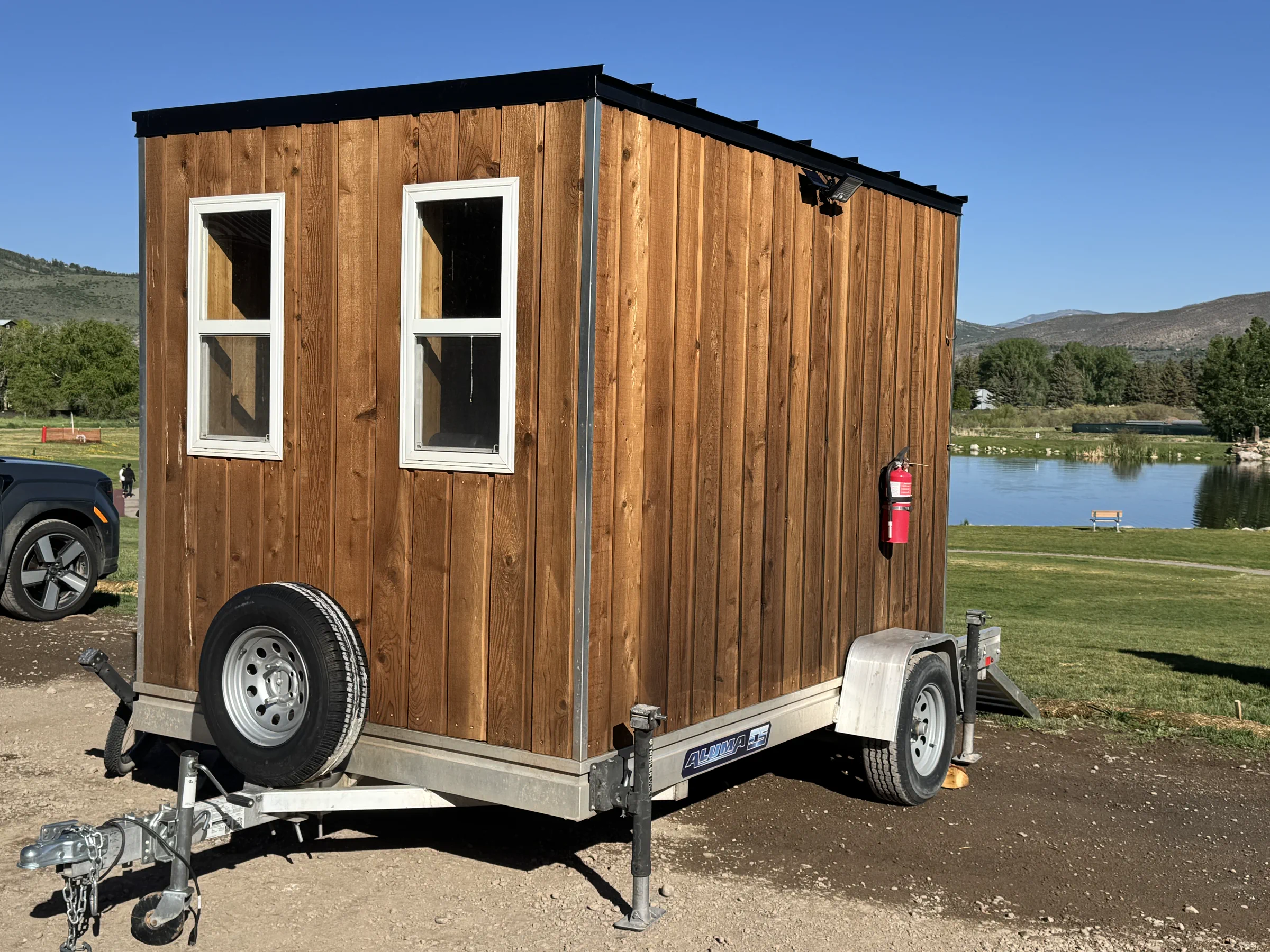 Mito Heat sauna trailer beside a lake with mountains beyond